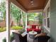 Covered back porch with outdoor seating, a red sofa, and views of the landscaped backyard at 3106 W Bay Villa Ave, Tampa, FL 33611