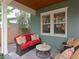 Relaxing covered back porch with wicker furniture, a red sofa, and lush landscaping at 3106 W Bay Villa Ave, Tampa, FL 33611