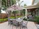 Expansive backyard patio with dining and seating areas, lush landscaping, and outdoor cooking space at 3106 W Bay Villa Ave, Tampa, FL 33611