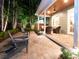 Outdoor patio with stone fire pit, seating area, and lush landscaping with ambient lighting for evening enjoyment at 3106 W Bay Villa Ave, Tampa, FL 33611