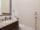 Powder room with granite countertop, dark wood vanity, oval sink, and decorative mirror at 3106 W Bay Villa Ave, Tampa, FL 33611