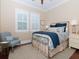 Bedroom with hardwood floors, two windows, and a comfortable seating area at 3106 W Bay Villa Ave, Tampa, FL 33611