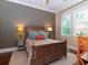 Bedroom with a queen bed, colorful bedding, two side tables, and a window for natural light at 3106 W Bay Villa Ave, Tampa, FL 33611