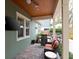 Beautiful covered patio with ceiling fan, outdoor television, barbecue, and seating area, perfect for relaxation at 3106 W Bay Villa Ave, Tampa, FL 33611