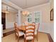 Charming dining area with a round wooden table, chandelier, wainscoting, and plenty of natural light from the windows at 3106 W Bay Villa Ave, Tampa, FL 33611