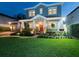 Beautiful two-story home at twilight boasts a lush green lawn, landscaped yard, and welcoming front porch at 3106 W Bay Villa Ave, Tampa, FL 33611