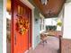 A red door with fall wreath. Comfortable seating on the front porch extends an invitation to relax at 3106 W Bay Villa Ave, Tampa, FL 33611