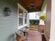 Cozy front porch featuring a swing, table, chairs, and a ceiling fan for comfortable seating at 3106 W Bay Villa Ave, Tampa, FL 33611