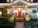 Inviting front porch with brick accents, potted plants, and a wreath on the red front door at 3106 W Bay Villa Ave, Tampa, FL 33611