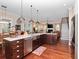Open kitchen with stainless steel appliances, an island with barstool seating, hardwood floors, and ample counter space at 3106 W Bay Villa Ave, Tampa, FL 33611