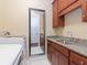 A laundry room features a sink with granite countertop, cabinets, a mirror, and a washing machine at 3106 W Bay Villa Ave, Tampa, FL 33611