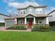 Two-story craftsman style home with a porch and landscaped lawn at 3106 W Bay Villa Ave, Tampa, FL 33611