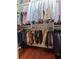 Organized walk-in closet featuring hanging shirts, pants, suits, and shoes on a hardwood floor at 3106 W Bay Villa Ave, Tampa, FL 33611
