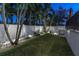 Evenning view of backyard with tropical landscaping and lighting at 3925 1St Ne St, St Petersburg, FL 33703