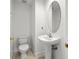 An elegant bathroom features a pedestal sink with an oval mirror and a comfort-height toilet at 403 S Oregon Ave, Tampa, FL 33606