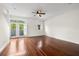 A spacious bedroom with wood floors, ceiling fan, and private balcony and additional window with shutters at 403 S Oregon Ave, Tampa, FL 33606