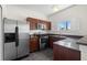 An eat-in kitchen features stainless steel appliances, wooden cabinets, granite countertops, and a window view at 403 S Oregon Ave, Tampa, FL 33606