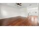 A large living room with wood floors, white walls, ceiling fan, and a view into the eat-in kitchen at 403 S Oregon Ave, Tampa, FL 33606