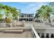 Waterfront home with a private dock, white fence, and palm trees at 452 Bath Club N Blvd, North Redington Beach, FL 33708