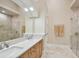 Double vanity bathroom with a large mirror and frameless glass shower at 602 Guisando De Avila, Tampa, FL 33613