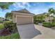 Attached garage with landscaping and driveway at 27133 Ipswich Dr, Englewood, FL 34223