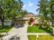 Charming one-story home with a red door and lush landscaping at 34701 Pinehurst Greene Way, Zephyrhills, FL 33541