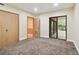 Spacious bedroom with carpet flooring, double doors leading to a patio, and access to a hallway at 36750 Us Highway 19 N # 03127, Palm Harbor, FL 34684