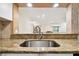 Stylish kitchen sink with granite countertop, stainless steel faucet, and tiled walls at 36750 Us Highway 19 N # 03127, Palm Harbor, FL 34684