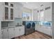 Bright laundry room with white cabinets, granite countertops and modern appliances at 3942 14Th Ne St, St Petersburg, FL 33703