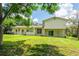 The back exterior of the home features a well-maintained lawn and sliding glass doors to the interior at 514 Crestover Dr, Temple Terrace, FL 33617