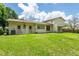 The back exterior of the home features a well-maintained lawn, dual doors, and air conditioning unit at 514 Crestover Dr, Temple Terrace, FL 33617