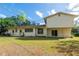 Grassy backyard featuring an open area and exterior views of the home with sliding glass doors at 514 Crestover Dr, Temple Terrace, FL 33617