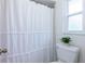 Bathroom with a white shower curtain, a toilet, and a bright window at 514 Crestover Dr, Temple Terrace, FL 33617