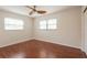 Bright bedroom featuring wood floors, two windows, and neutral paint at 514 Crestover Dr, Temple Terrace, FL 33617