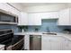 Modern kitchen features stainless steel appliances, white cabinets and a stylish backsplash at 514 Crestover Dr, Temple Terrace, FL 33617
