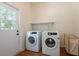 Bright laundry room featuring a washer, dryer, and a backyard view at 514 Crestover Dr, Temple Terrace, FL 33617