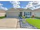 Modern house exterior with a two-car garage, well-manicured lawn, and attractive landscaping at 555 Calico Scallop St, Ruskin, FL 33570