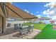 Outdoor patio with retractable awning, comfortable seating, and a manicured lawn at 555 Calico Scallop St, Ruskin, FL 33570