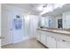 Clean bathroom with double sinks, shower, and walk-in closet at 555 Calico Scallop St, Ruskin, FL 33570