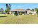 Home's rear elevation showcasing a covered patio and well-manicured lawn at 719 Winterbrooke Way, Sun City Center, FL 33573