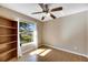Bedroom with wood floors, large window, and built-in shelves at 719 Winterbrooke Way, Sun City Center, FL 33573