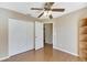 Bedroom with wood flooring, ceiling fan, and built-in shelving at 719 Winterbrooke Way, Sun City Center, FL 33573