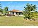 Home's back elevation with covered patio and landscaping at 719 Winterbrooke Way, Sun City Center, FL 33573
