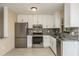 Modern kitchen with white cabinets, granite countertops, and stainless steel appliances at 8832 Huntsman Ln, Port Richey, FL 34668