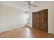 Bedroom with wood-look flooring, ceiling fan, and louvered closet doors at 914 Willowood Ln, Dunedin, FL 34698