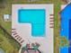 Aerial view of a community pool with lounge chairs, a covered area, and a tennis court at 914 Willowood Ln, Dunedin, FL 34698