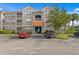 Two-story building with gray siding, orange roof, and ample parking at 18001 Richmond Place Dr # 734, Tampa, FL 33647