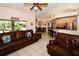 Living room with leather furniture, views of the kitchen and pool area at 3204 Stagecoach Trl, Wimauma, FL 33598
