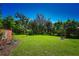 Open backyard with lush grass and a red storage shed at 3204 Stagecoach Trl, Wimauma, FL 33598