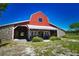 Red barn with stone accents, offering ample space and storage at 3204 Stagecoach Trl, Wimauma, FL 33598